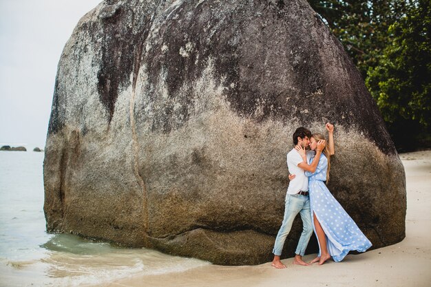 Pareja joven inconformista con estilo en el amor en la playa tropical durante las vacaciones