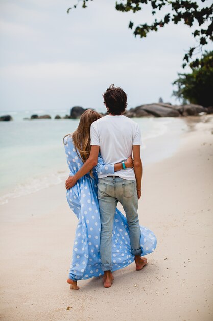 Pareja joven inconformista con estilo en el amor en la playa tropical durante las vacaciones