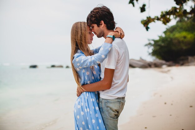 Pareja joven inconformista con estilo en el amor en la playa tropical durante las vacaciones