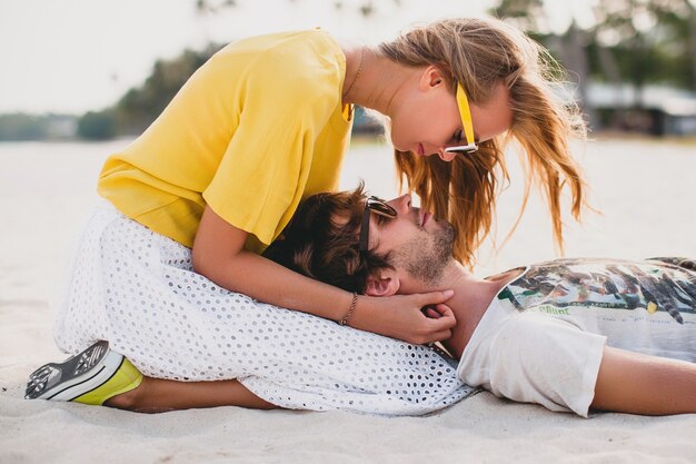 Pareja joven inconformista con estilo en el amor en la playa tropical durante las vacaciones