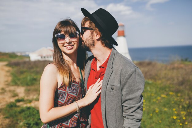 Pareja joven inconformista estilo indie enamorado caminando en el campo