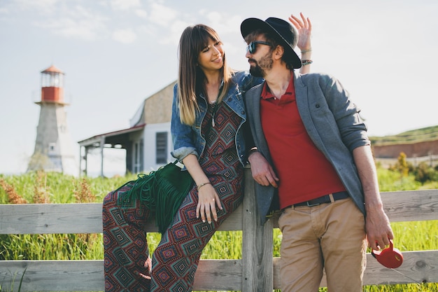 Pareja joven inconformista estilo indie enamorado caminando en el campo