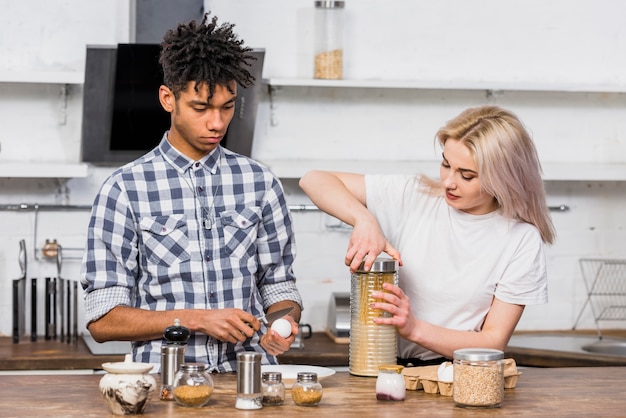 Foto gratuita pareja joven interracial preparando los espaguetis en la cocina