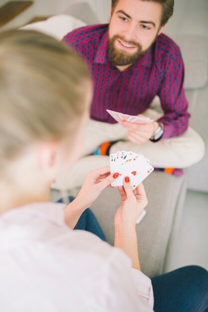 Pareja joven jugando a las cartas en casa