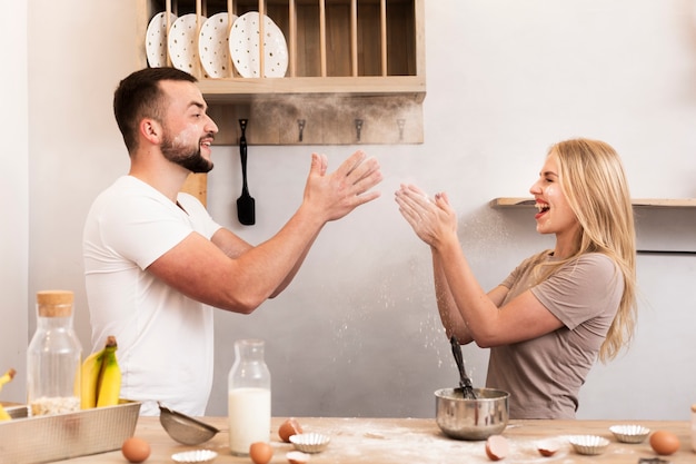 Foto gratuita pareja joven jugando en la cocina