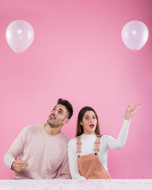 Foto gratuita pareja joven jugando con globos blancos