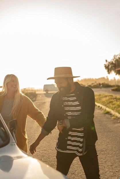 Pareja joven jugando en su viaje en coche