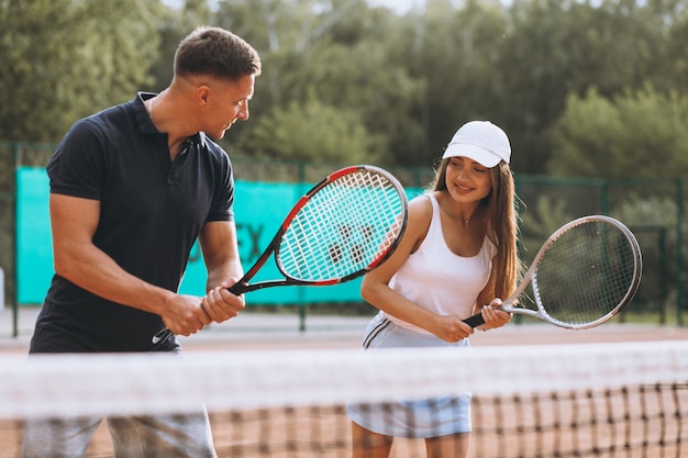 Pareja joven jugando tenis en la cancha