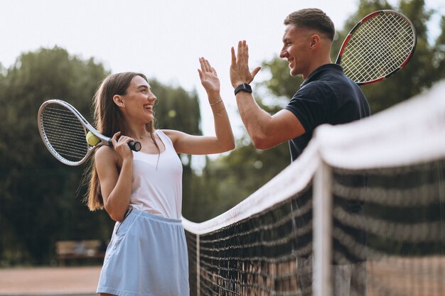 Pareja joven jugando tenis en la cancha