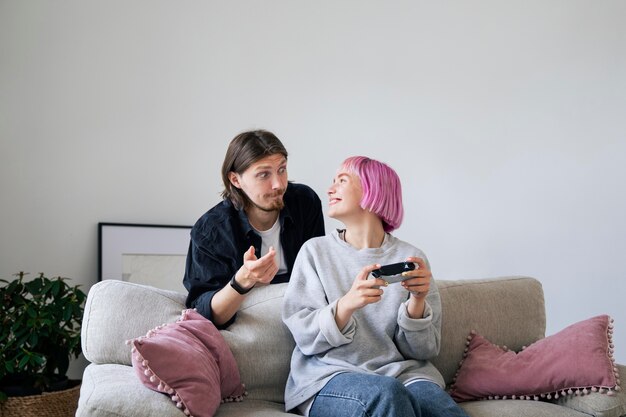 Foto gratuita pareja joven jugando un videojuego en casa