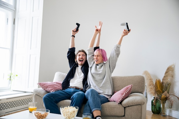 Foto gratuita pareja joven jugando un videojuego en casa