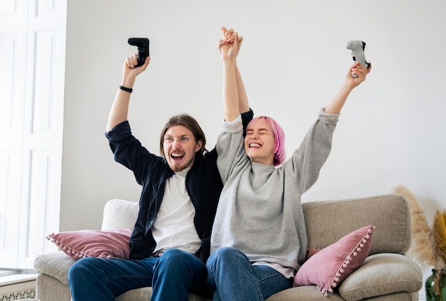 Foto gratuita pareja joven jugando un videojuego en casa