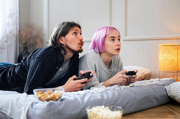 Pareja joven jugando a un videojuego en el interior