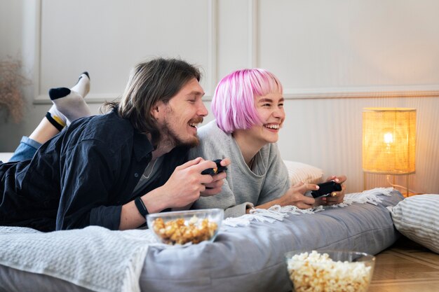 Pareja joven jugando a un videojuego en el interior