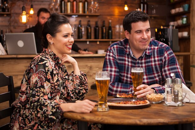 Pareja joven junto a pasar un buen rato. Pizza deliciosa.