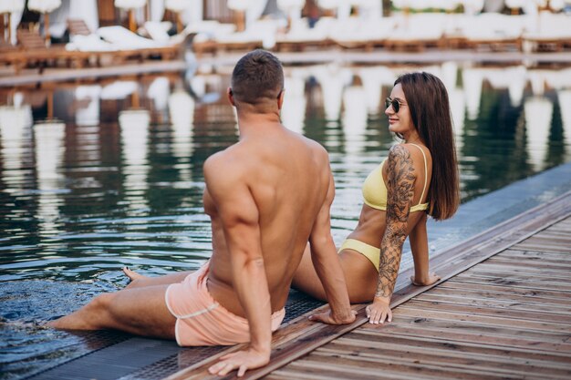 Pareja joven junto a la piscina