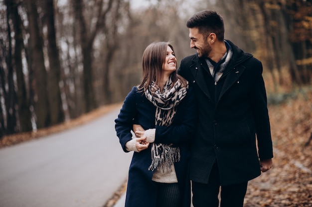 Pareja joven juntos caminando en un parque de otoño