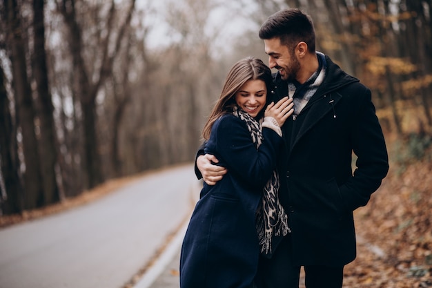 Pareja joven juntos caminando en un parque de otoño