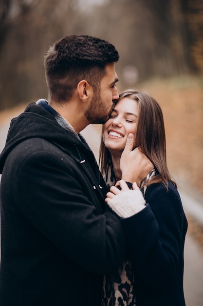 Pareja joven juntos caminando en un parque de otoño