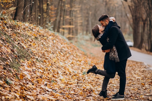 Pareja joven juntos caminando en un parque de otoño