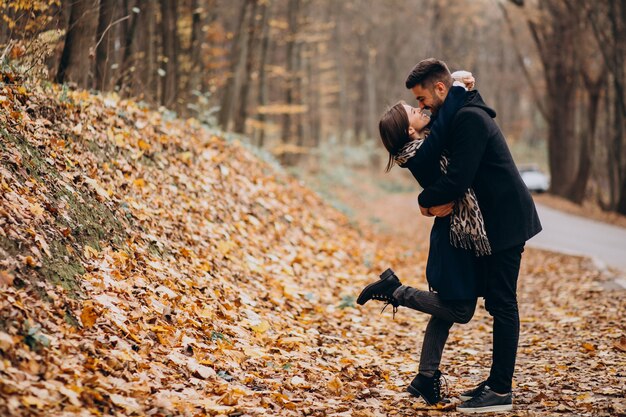 Pareja joven juntos caminando en un parque de otoño