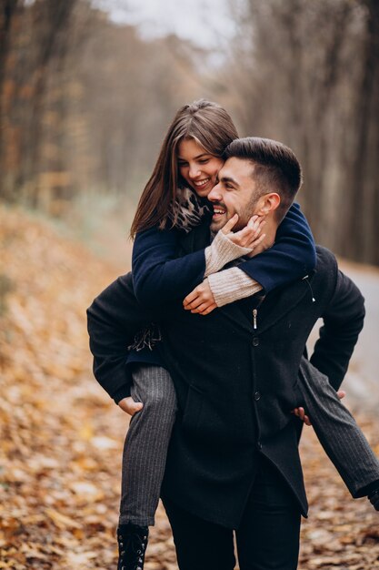 Pareja joven juntos caminando en un parque de otoño