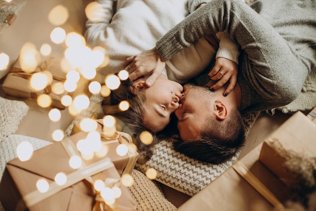 Pareja joven, juntos, en la víspera de navidad, acostado, debajo, el, árbol