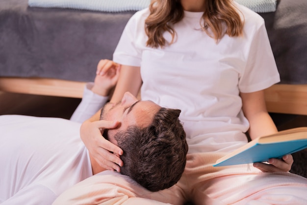 Foto gratuita pareja joven leyendo libro en dormitorio