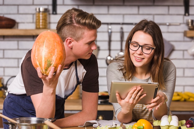 Pareja joven leyendo receta juntos