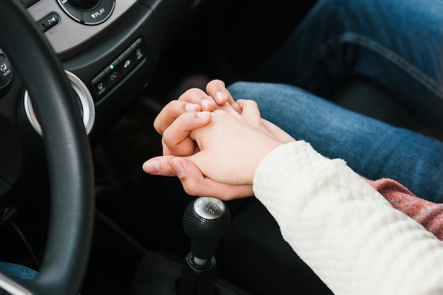 Pareja joven, manos de valor en cartera, en coche