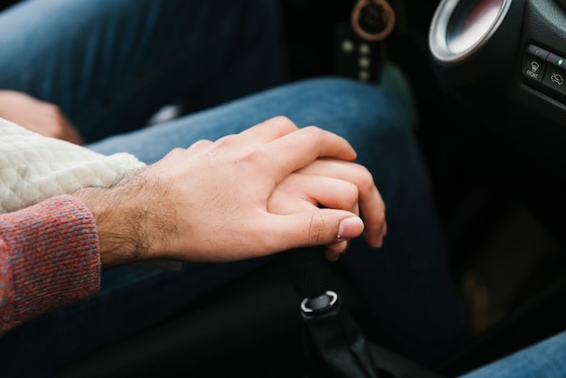 Pareja joven, manos de valor en cartera, en coche