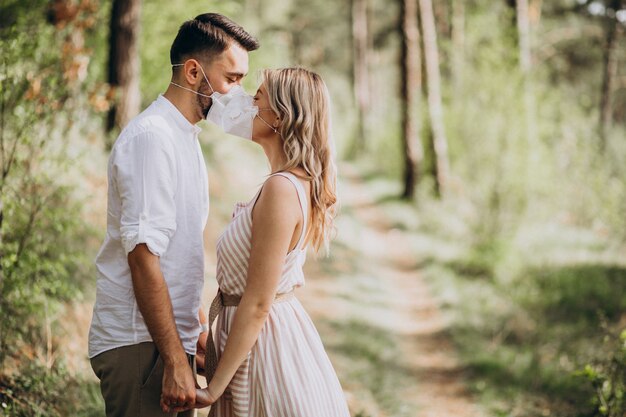 Pareja joven con máscaras juntas en el bosque