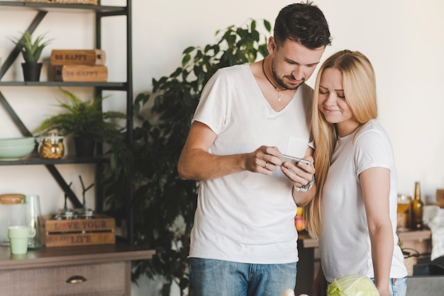 Foto gratuita pareja joven mirando celular