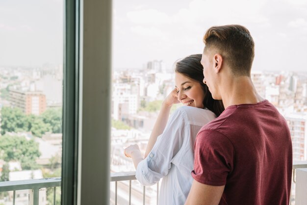 Pareja joven mirando a la ciudad desde el balcón