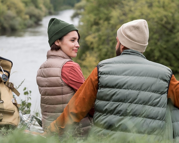 Foto gratuita pareja joven mirándose cerca del río