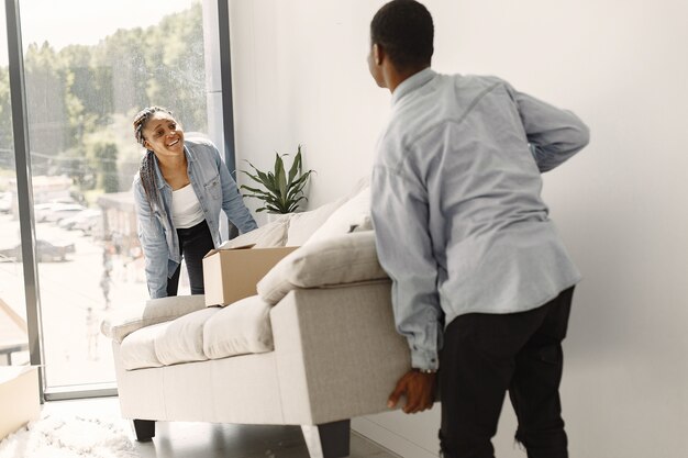 Pareja joven mudándose juntos al nuevo hogar. Pareja afroamericana con cajas de cartón.