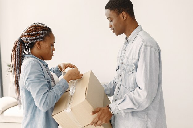 Pareja joven mudándose juntos al nuevo hogar. Pareja afroamericana con cajas de cartón.