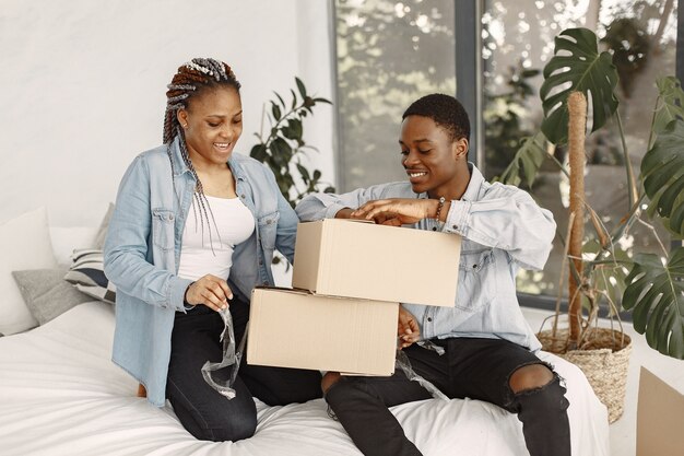Pareja joven mudándose juntos al nuevo hogar. Pareja afroamericana con cajas de cartón.
