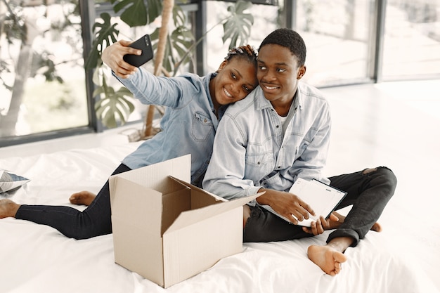 Pareja joven mudándose juntos al nuevo hogar. Pareja afroamericana con cajas de cartón.