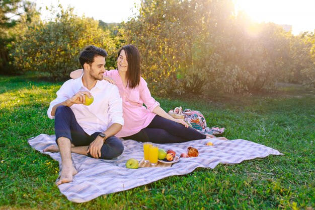 Pareja joven en el parque al aire libre haciendo un picnic