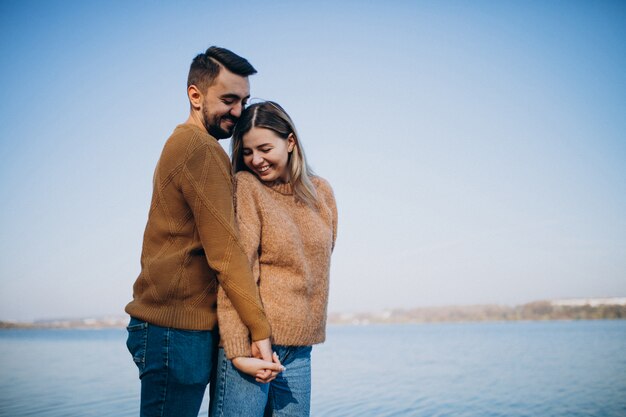 Pareja joven en el parque de pie junto al río