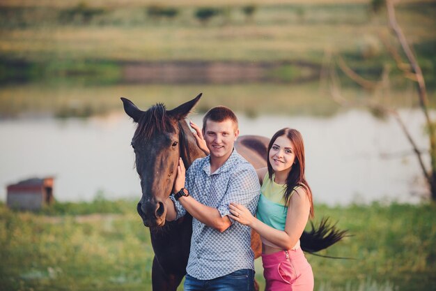 Pareja joven pasando tiempo junto con su caballo