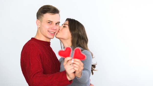 Pareja joven con pequeños corazones en las manos