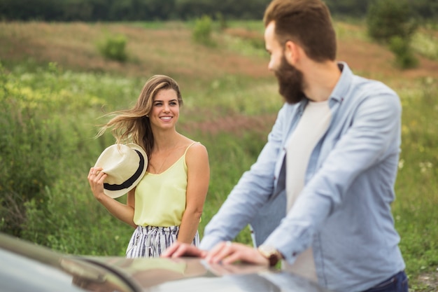 Pareja joven de pie en el campo mirando el uno al otro