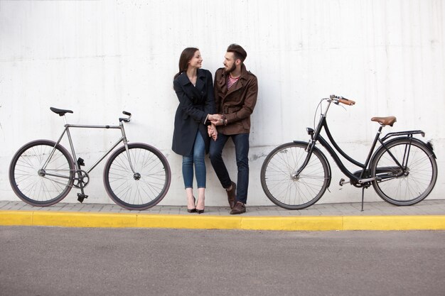 Pareja joven de pie contra la pared y abrazando