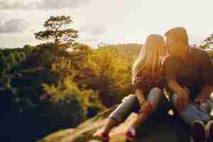 Foto gratuita pareja joven plantea en las rocas con gran paisaje de montaña detrás