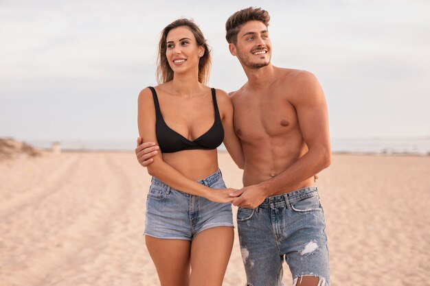 Pareja joven en la playa abrazando