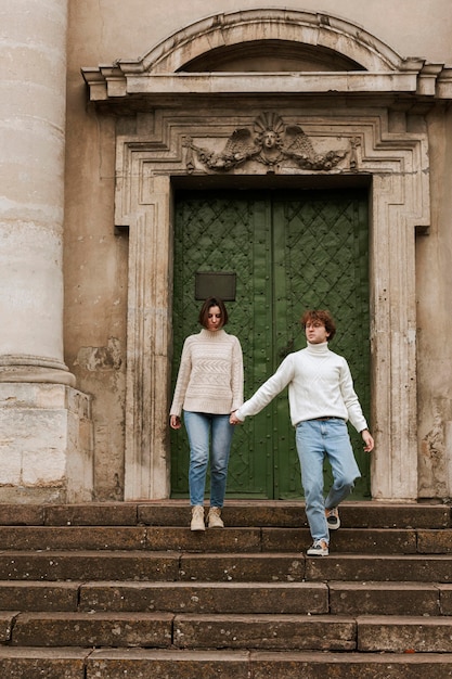 Foto gratuita pareja joven, posar, al lado de una puerta