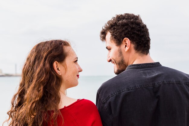 Pareja joven, posición, en, orilla de mar