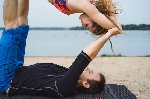 pareja joven practicando yoga en el fondo de la ciudad